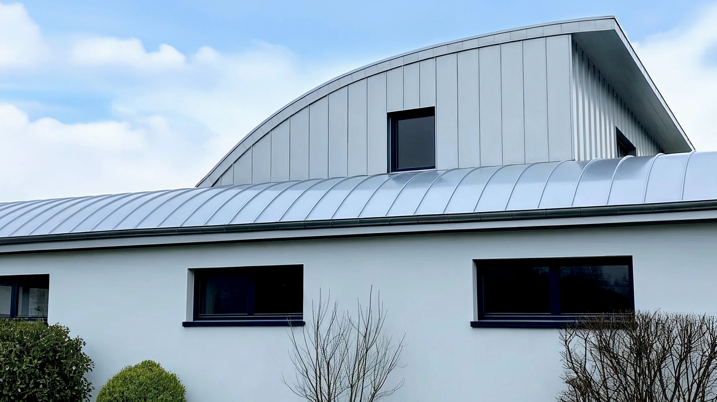 Extérieur résidentiel avec système de gouttières en PVC anthracite installé sur toiture