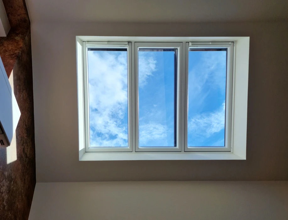 Toiture résidentielle avec tuiles métalliques grises sous ciel bleu