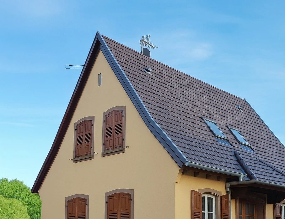 Chantier de rénovation de toiture en extérieur avec pose de tuiles terre cuite sur charpente bois apparente