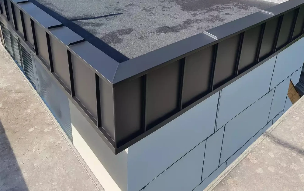 Chantier de construction extérieur avec toiture métallique bleue en cours d'installation sur charpente bois