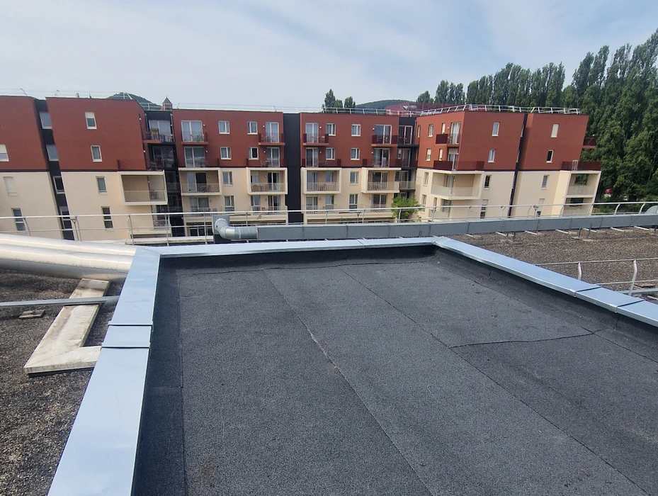 Chantier de construction extérieur avec toiture métallique bleue en cours d'installation sur charpente bois