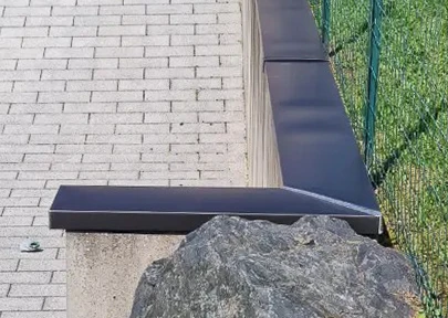 Chantier de construction extérieur avec toiture métallique bleue en cours d'installation sur charpente bois