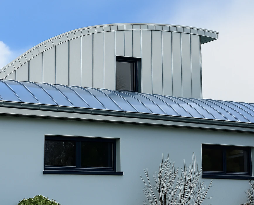 Toiture résidentielle avec tuiles métalliques grises sous ciel bleu